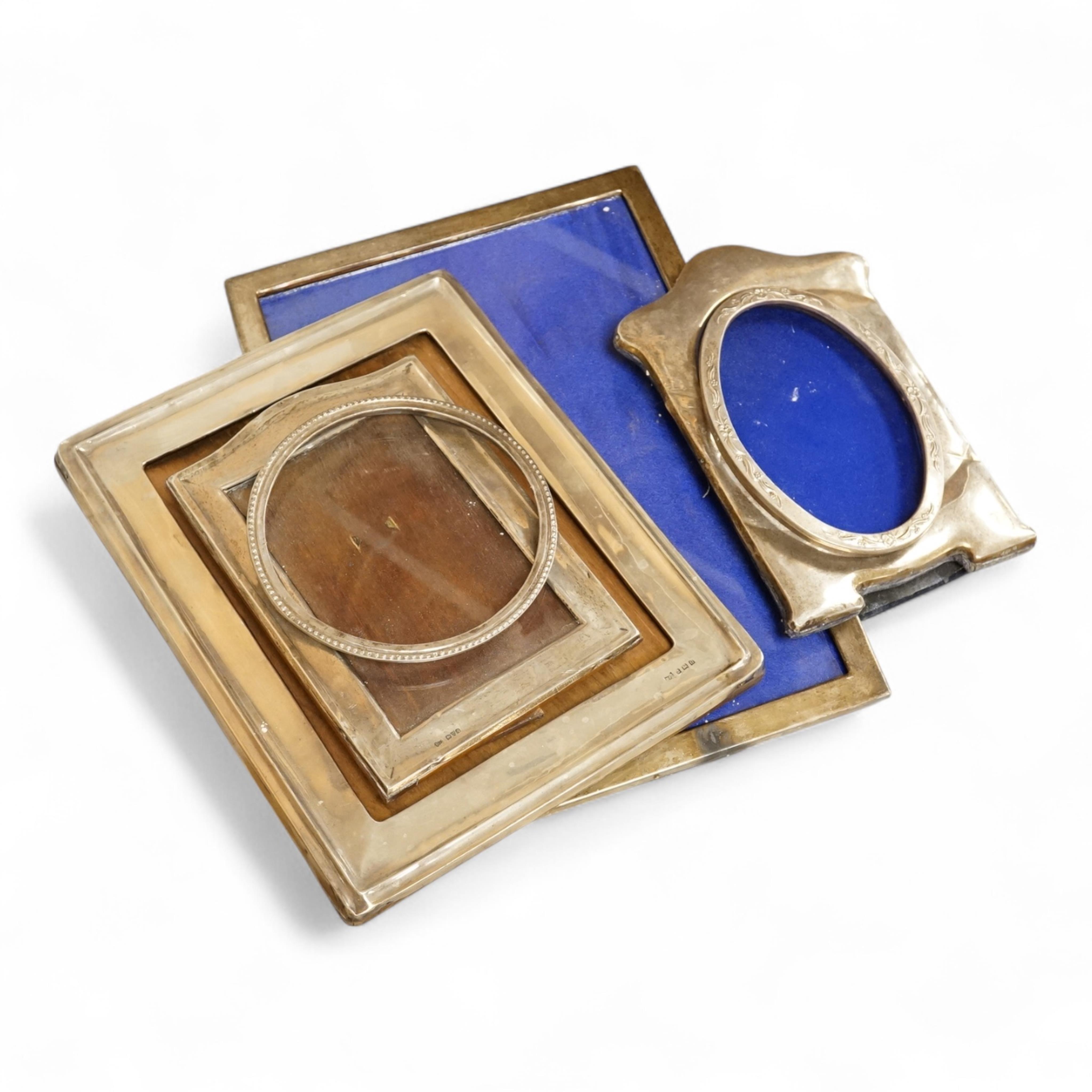 Four assorted early 20th century silver mounted photograph frames, the largest by Sanders & Mackenzie, Birmingham, 1915, 30.3cm by 21.6cm, together with two small Spanish white metal mounted photograph frames.